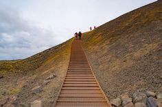 several people are walking up a steep hill