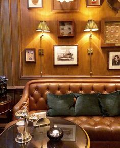 a living room filled with furniture and framed pictures on the wall above it's coffee table