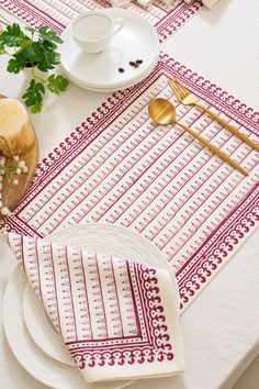 a white table topped with plates and silverware