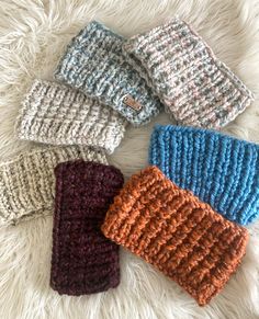 four crocheted mittens laying on top of a white furnishing area