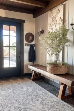 a wooden bench sitting in front of a door next to a plant on top of a table