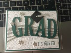 a laptop computer sitting on top of a desk next to a card with the words grad it's your day