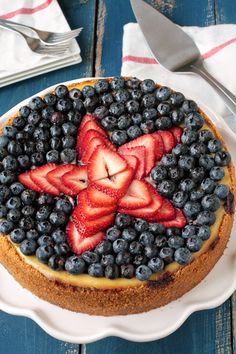 a cake with blueberries and strawberries in the shape of a star on top