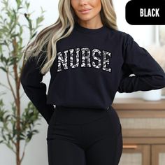 Camo Nurse Long-Sleeve - Gray & White Comfort Colors Top Grey and white camo nurse college font on a long-sleeve comfort colors shirt is the ultimate wardrobe staple for nurses and nursing students alike. This stylish shirt features a modern camo design in subtle grey and white tones, paired with bold college font that showcases your nursing pride. Crafted from soft and durable comfort colors material, this shirt is perfect for all-day wear. Whether you're attending classes, working long shifts, Black Graphic Print Nursing Top, Black Nursing Top With Graphic Print, Casual Black Nursing Top, Long Sleeve Cotton Nursing Tops, Relaxed Fit Long Sleeve Nursing Top, Casual Long Sleeve Nursing Tops, Casual Long Sleeve Nursing T-shirt, Relaxed Fit Nursing Tops With Crew Neck, Fall Crew Neck Nursing Top