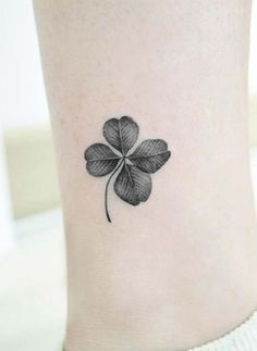 a small four leaf clover tattoo on the side of a woman's leg,