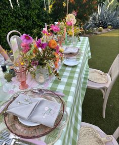 the table is set with flowers and plates