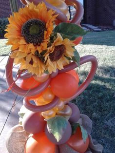 an arrangement of fruits and vegetables is displayed on a table outside in the sunflowers