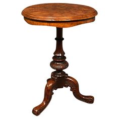 an antique wooden table with carved legs and a round top on the pedestal is isolated against a white background