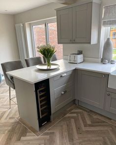 a kitchen with an island and wine rack in the center, next to a window