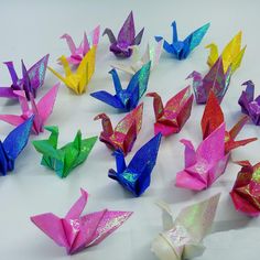 many colorful origami birds on a white surface