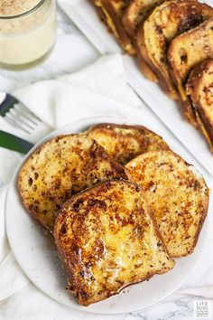 grilled french toast on a white plate next to a glass of milk