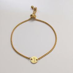 Add a personalized touch to your summer wardrobe with our Adjustable Gold-Plated Initial Bracelet. This elegant, minimalist bracelet is crafted from 18K gold-plated stainless steel and features a customizable charm that can be engraved with a lucky letter or the initial of a name, making it a unique and meaningful accessory. The bracelet's maximum length is 9.8 inches and it includes a convenient length adjuster for a perfect fit. The charm measures 0.36 inches in diameter, adding a delicate yet Bracelet Initial, Wedding Jewelry Bracelets, Initial Bracelet, Minimalist Bracelet, Summer Gift, Wedding Bracelet, Perfect Summer, Everyday Look, Special Events