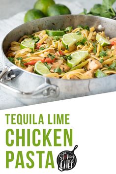 a pan filled with chicken pasta and garnished with limes