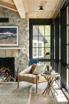 a living room filled with furniture and a fire place in front of a stone fireplace