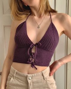 a woman with blonde hair wearing a purple crop top