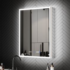 a bathroom sink with a lighted mirror above it