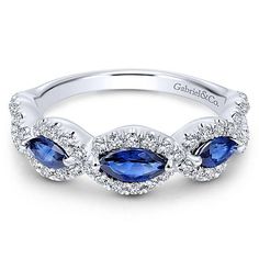 an 18k white gold ring with blue sapphires and diamonds on the sides, set in