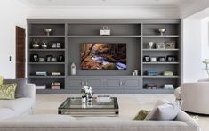 a living room filled with furniture and a flat screen tv mounted on a wall above a fireplace