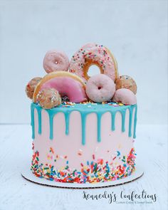 a birthday cake with donuts and sprinkles on top, sitting on a table