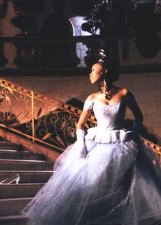 a woman in a white dress standing on some stairs