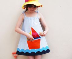 We think you will love the striking simplicity of this applique sun dress. Our out to sea  sun dress makes the perfect pocket pinafore for summer beach holidays. Featuring a rainbow sail boat , silver birds ,and a wave design running around the hemline. The simple design means a perfect easy fit with tie straps and soft chest elastic. Layer with a short sleeve vest top. Made from sky blue cool Linen cotton mix with cotton applique  30 degree wash.Gentle cycle. Iron on reverse. Handmade in the UK Playful Cotton Sundress For Beach, Playful Cotton Sundress For The Beach, Blue Nautical Dress For Summer, Nautical Sleeveless Dresses For The Beach, Nautical Sleeveless Beach Dress, Blue Nautical Summer Dress, Nautical Dresses For Summer Vacation, Nautical Style Summer Vacation Dresses, Nautical Cotton Summer Dress