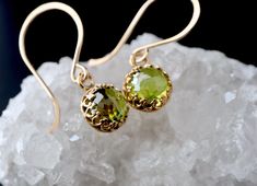 "8mm rose cut, lab created Peridot in an intricate crown bezel setting are suspended from luxe handmade French hooks. Available in your choice of 14k yellow gold fill, rose gold fill, or sterling silver. The gold filled options include premium plated bezels.  :: FIT :: Earrings measure just over 1\" in length, including the ear wire.  GOLD FILL  A thick layer of solid gold heat bonded to an inner core of brass or silver. Lasts decades. Hypoallergenic. Clean and polish just like solid gold. :: CO Elegant Peridot Birthstone Earrings, Elegant Peridot Earrings For Wedding, Elegant Peridot Jewelry With Prong Setting, Elegant Peridot Round Jewelry, Elegant Round Peridot Stone Jewelry, Peridot Earrings, Birthday Jewelry Gift, August Birth Stone, 14kt Gold