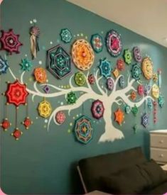 the wall is decorated with colorful crochet pieces and has a tree on it