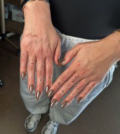 a woman's hands with tattoos on them