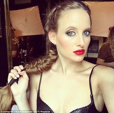 a woman with braids and red lipstick in a black bra top is looking at the camera