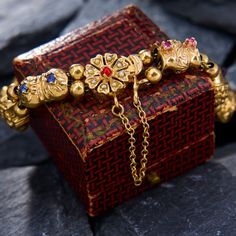 a red and gold box sitting on top of a rock