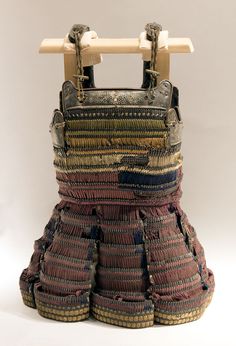 an old woven purse sitting on top of a wooden stand