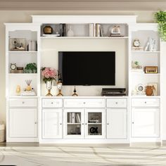 a living room with white furniture and a flat screen tv mounted on the wall above it