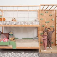 two children standing in front of a bunk bed