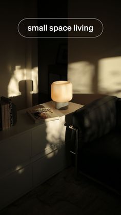 a living room with a couch, lamp and small space living sign on the wall