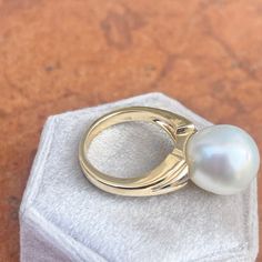 Two-tone 14KT white gold + yellow gold band ring with genuine, cultured Paspaley South Sea Pearl. Choose your finger size Contact us for additional sizes 12mm Paspaley Pearl; "Fine" quality; "Circle" shape Paspaley Certificate of Authenticity included Weight: 6.31g Made to order: please allow 7-10 business days prior to shipping Pearl will vary slightly from photos Classic White Pearl Open Ring, Classic White Oval Dome Ring, Classic White Dome Ring For Wedding, White Pearl Ring With Round Band, Fine Jewelry White Pearl Ring With Round Band, White Pearl Ring Fine Jewelry, White Round Dome Ring For Anniversary, White 14k Oval Pearl Ring, White Dome Ring Fine Jewelry