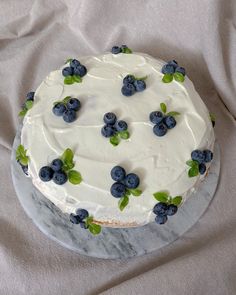 a cake with white frosting and blueberries on it