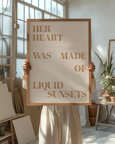 a woman holding up a sign that says her heart was made of liquid sunscreens