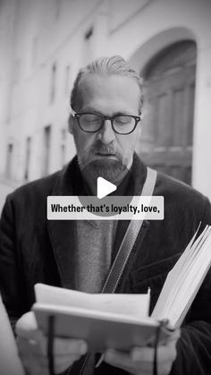 a man with glasses is reading a book