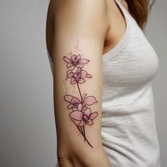 a woman with a tattoo on her arm has a pink flower in the middle of her arm