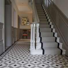 a staircase with black and white tiles on the floor