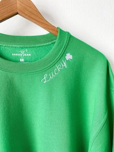 Maybe it's the luck of the Irish! This design is embroidered on a festive green crewneck sweatshirt with white thread for festive, holiday apparel! It is unisex sized. This means the sizing is boxy, not fitted like women's, but it is not oversized. It is true to size. This design is not customizable. This design and colors cannot be altered, resized, or changed. Specifications: 8 oz.(US) 13.3 oz.(CA), 50/50 preshrunk cotton/polyester Heather Sport colors: 60/40 polyester/cotton Air jet yarn = so Green Long Sleeve Sweater With Embroidered Text, Green Embroidered Crew Neck Sweater, Green Crew Neck Sweatshirt With Embroidered Text, Green Crew Neck Sweatshirt With Letter Embroidery, Green Crew Neck Top With Letter Embroidery, Green Embroidered Text Sweatshirt For Winter, Custom Crewneck Sweatshirts, Lucky Leaf, Custom Crewneck