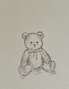 a drawing of a teddy bear sitting on the ground in front of a white wall