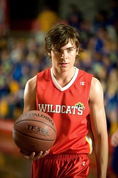 a young man holding a basketball in his hand