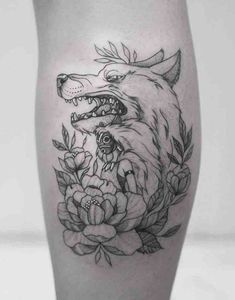 a tattoo on the leg of a woman with flowers and a wolf's head