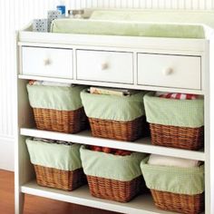 a baby changing table with baskets on it