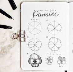 an open notebook with drawings and pens on it, including the title how to draw pansies