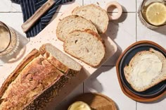 sliced bread and butter on a cutting board next to two bowls with lemonade in them