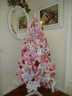 a white christmas tree with pink and red decorations