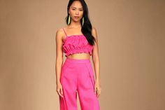 a woman wearing pink pants and a crop top