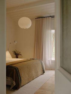 a bedroom with a large bed and white curtains